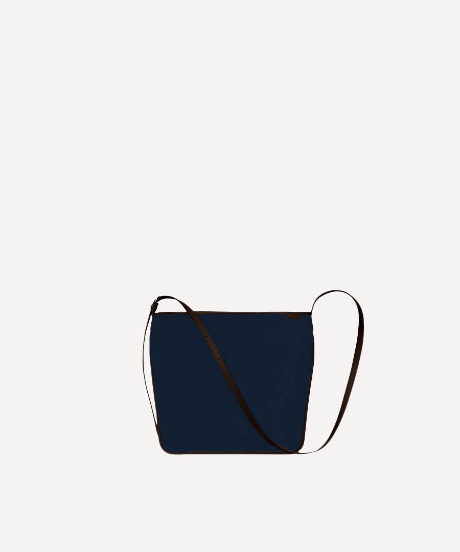 Le sac Petit Postier L/UNIFORM en toile marine et en cuir chocolat vue de face