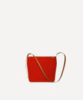 Le sac Petit Postier L/UNIFORM en toile rouge et en cuir marron vue de face