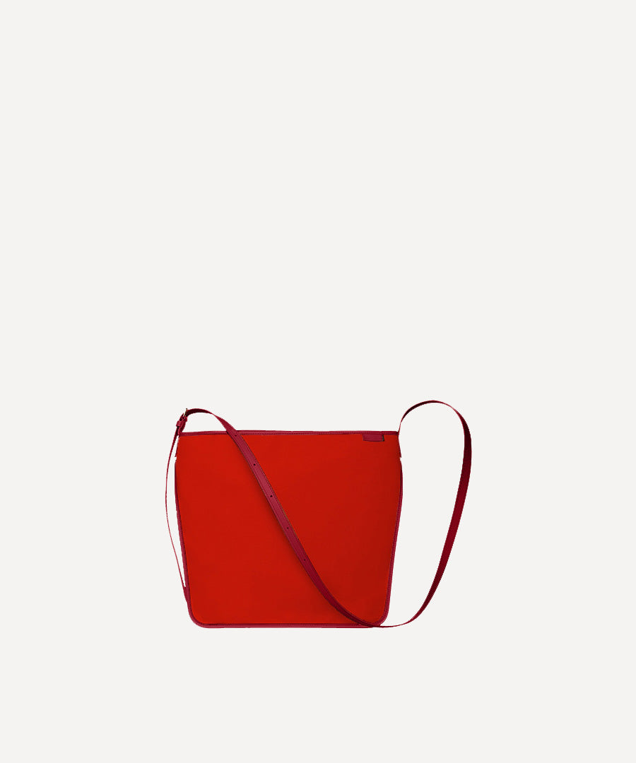 Le sac Petit Postier L/UNIFORM en toile rouge et en cuir carmin vue de face